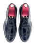 Pair of black dress shoes with red lining on a white background