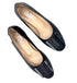 Pair of black flat shoes with a metallic cap toe on a white background
