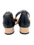 Black high-heeled shoes with beige soles on a white background